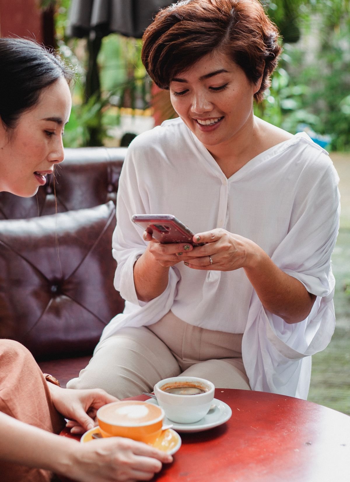 Gast in een café lacht met de telefoon in de hand